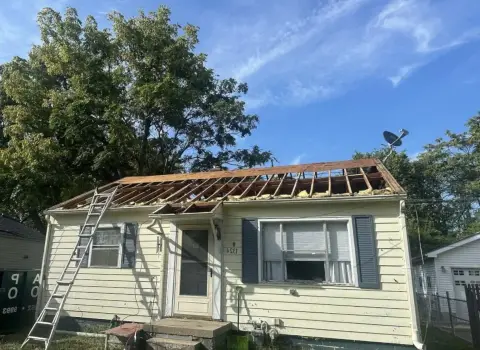 Roof tear-off on a single-story bungalow exposing the rafters